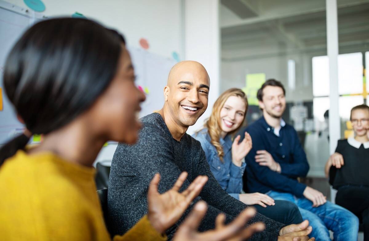 Man met andere mensen in gesprek, zittend op stoelen in een kring.